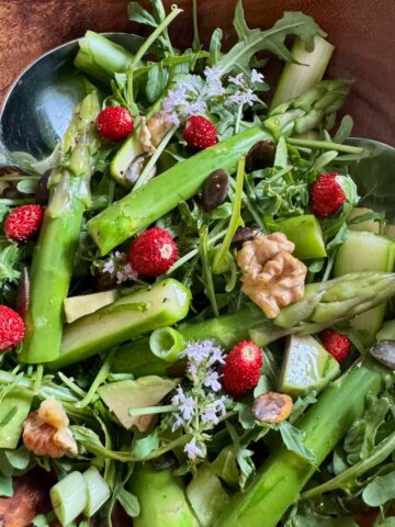 tossed green salad with seasonal fresh vegetables such as arugula, avocado and other greens with toasted nuts and seeds